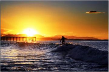 surfer-on-perfect-morning-out-on-water-sun-coming-up-bright